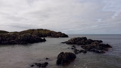 Vista-Aérea-De-La-Isla-De-Llanddwyn,-Playa-Rocosa-Costera-De-Anglesey-A-Través-Del-Mar-De-Irlanda