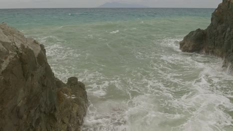 Vista-Aérea-Sobre-Las-Olas-Del-Océano-Volando-Entre-Rocas-En-La-Playa-De-Banbanon-En-Filipinas