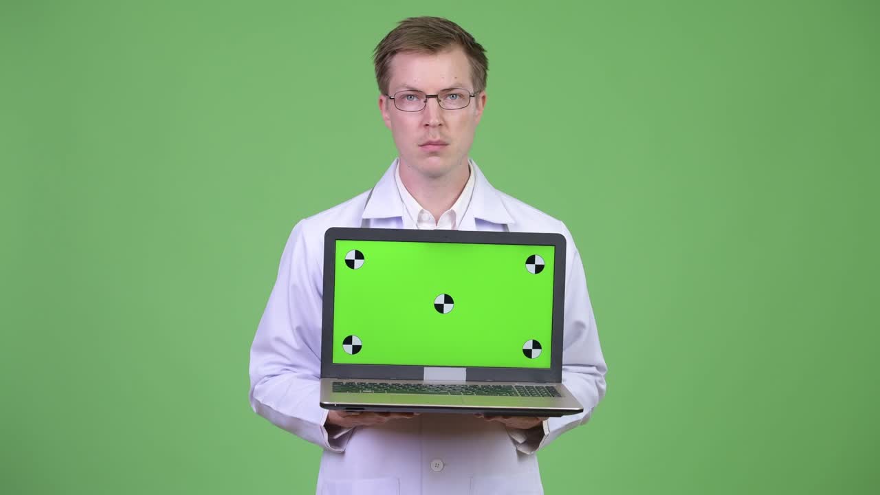 hombre feliz médico mostrando chroma clave pantalla verde computadora portátil