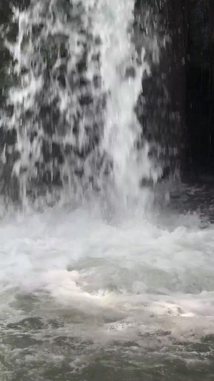 Primo piano dell'acqua che scende a cascata da una piccola cascata.