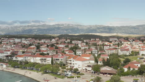 AERIAL:-Flight-over-vacation-houses-villas-in-Novalja,-Croatia-Nature-with-blue-sky-and-sun