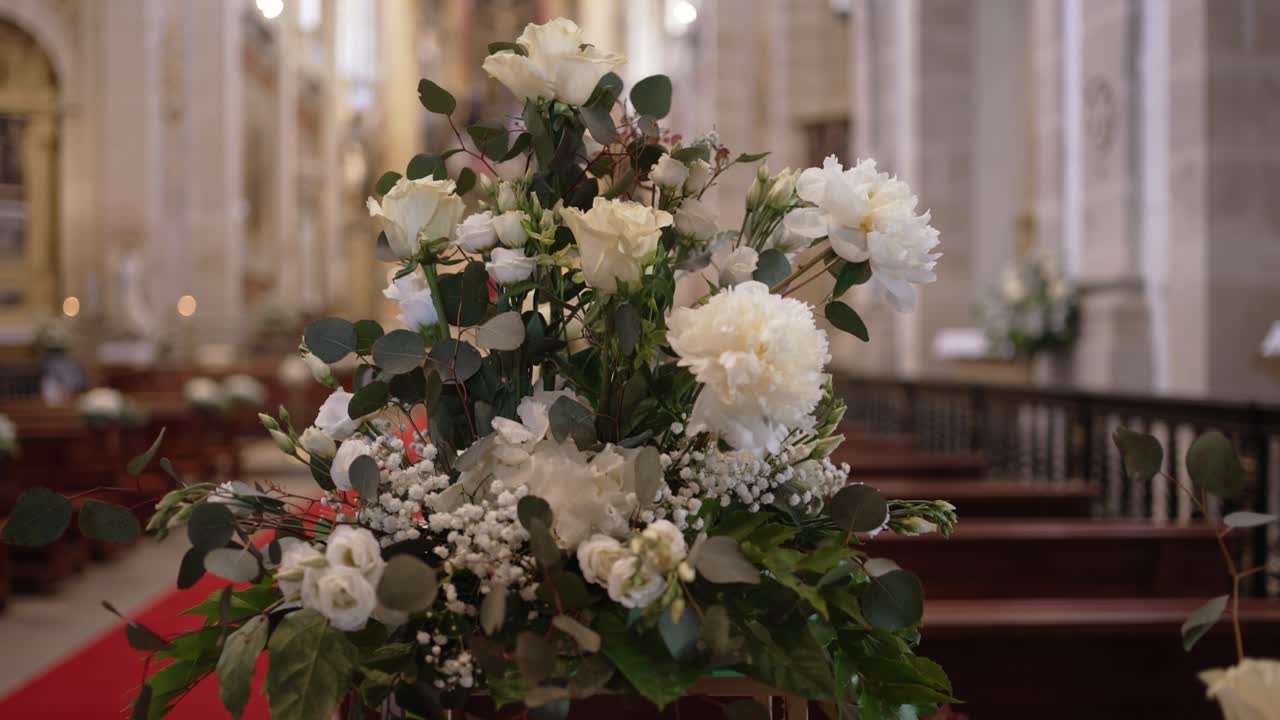 white roses and greenery arranged for wedding in historic church
