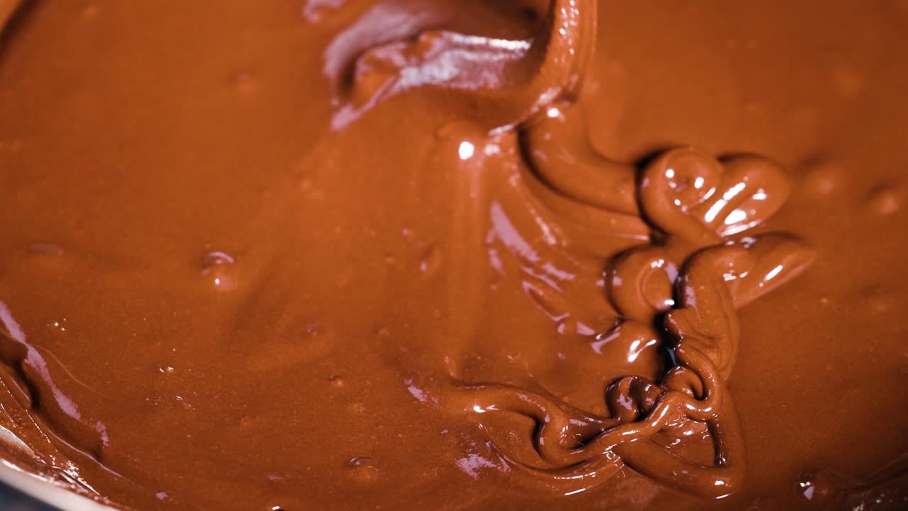 A spoon stirs rich, melted chocolate