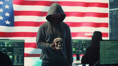 American-man-in-a-dark-hood-making-death-threats-with-human-skull-concept