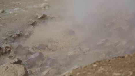 steaming methane and mineral pool bubbles and froths against light rocks and mud