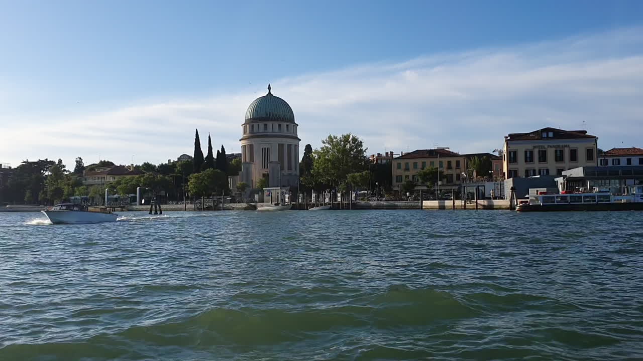 venecia desde un barco que navega la luz del sol en el agua salpica 30 fotogramas por segundo con la isla de la cúpula de la iglesia 14_seg