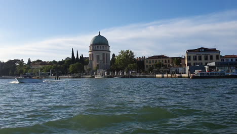 Venecia-Desde-Un-Barco-Que-Navega-La-Luz-Del-Sol-En-El-Agua-Salpica-30-Fotogramas-Por-Segundo-Con-La-Isla-De-La-Cúpula-De-La-Iglesia-14_seg