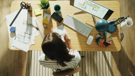 architect working on house plans at a desk