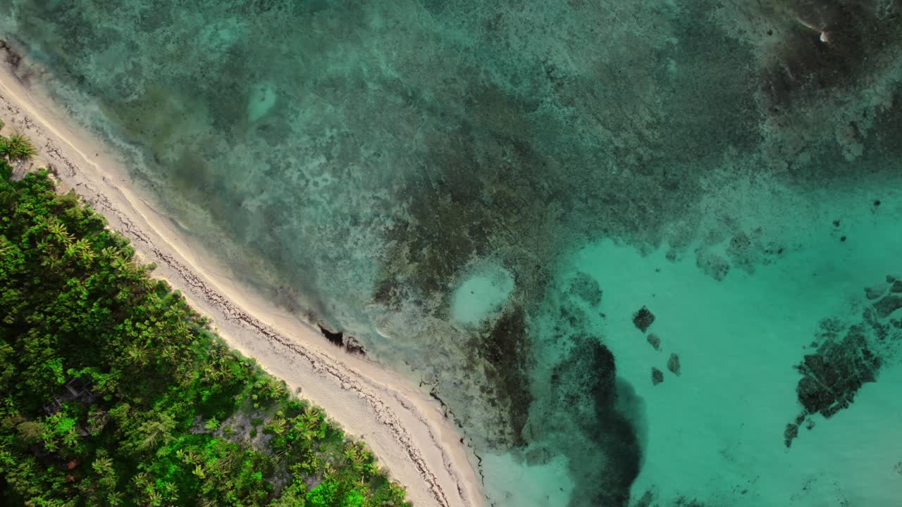From a top-down perspective, an aerial view captures the shallow waters of Xpuha Beach in Riviera Maya, Mexico