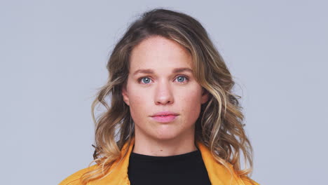 head and shoulders studio shot of woman looking at camera with serious expression in slow motion