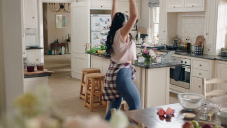 una adolescente con sobrepeso feliz bailando en la cocina divirtiéndose celebrando el fin de semana realizando movimientos de baile divertidos escuchando música usando auriculares