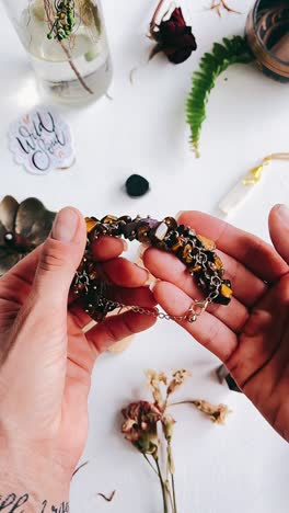woman's hands holding a tiger's eye bracelet