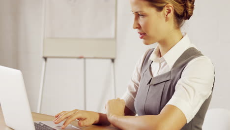 una mujer de negocios seria usando su portátil.