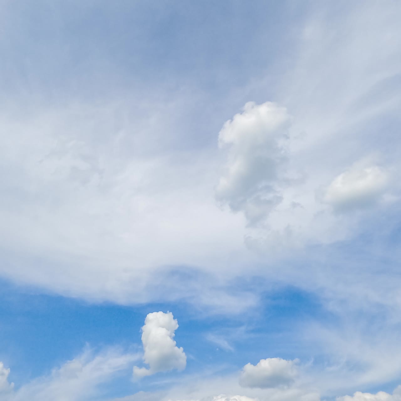 Amazing light spindrift clouds covering the sky. Soft puffy little clouds flying past. Low angle timelapse