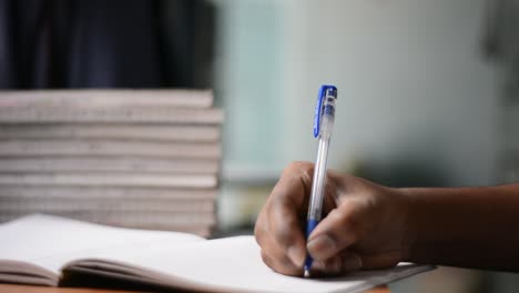 rotating pen with hand on the book while thinking to write something