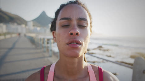 manchas de luz contra el primer plano de una cansada mujer afroamericana en forma tomando un descanso de correr