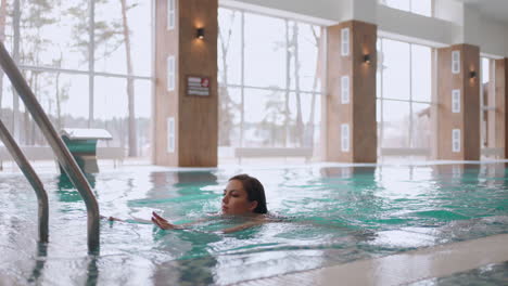 rest in modern wellness center woman is swimming in indoor pool relax in spa healthy lifestyle thermal complex