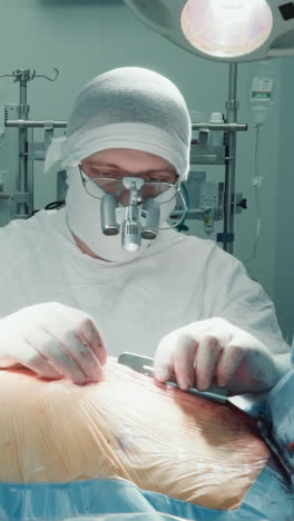 el cirujano instala un retractor en el pecho del paciente. el médico enfocado expande la incisión para la conducción de cirugía de derivación de la arteria coronaria en el hospital de cardiología
