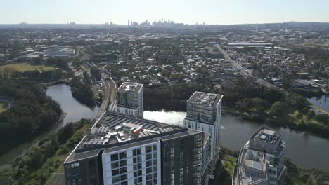 aerial drone fly over the high rise apartment complexes at wolli creek suburb with sydney cbd cityscape in the background