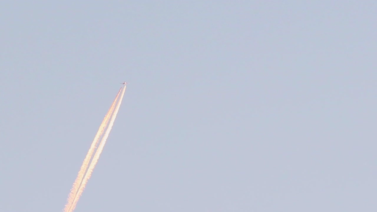 vista de cerca del avión del reactor a reacción cruzando el cielo azul dejando una larga estela blanca