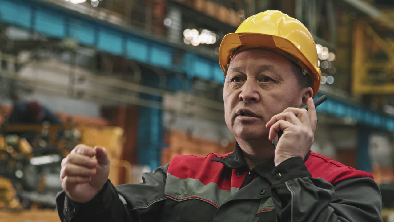 Asian Plant Supervisor Talking On Walkie-Talkie