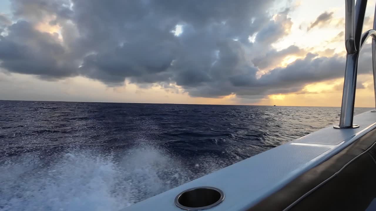 View from fast motorboat cruising through the Caribbean Sea at sunset