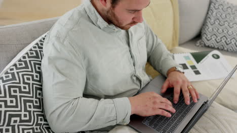 documents, laptop and businessman typing on sofa