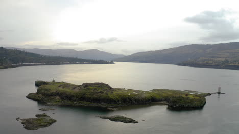 Overcast Landscape of a Wide River with an Island and Distant Mountains