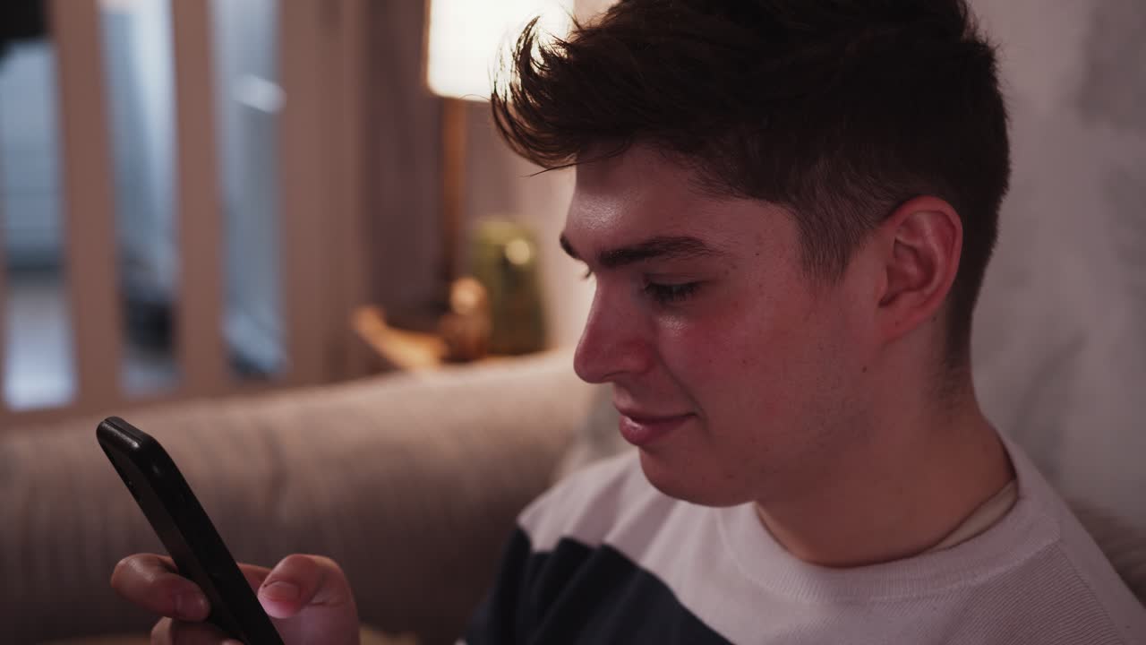 젊은이 는 스마트폰 을 보고 있는 동안 자기 자신 에게 웃는다