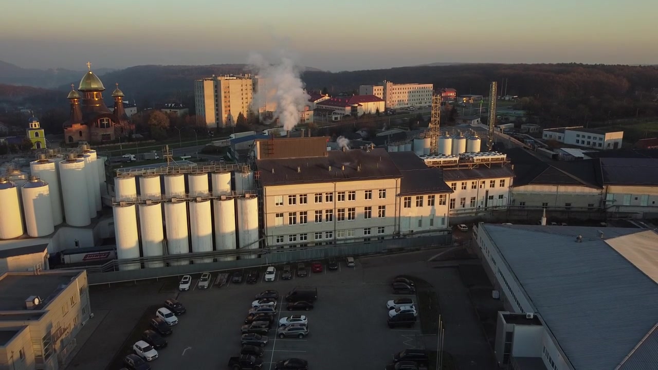 Vista aerea di un drone che sorvola il birrificio, diverse file di serbatoi