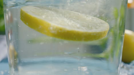 una rodaja de limón caída en el agua con un salpico dinámico