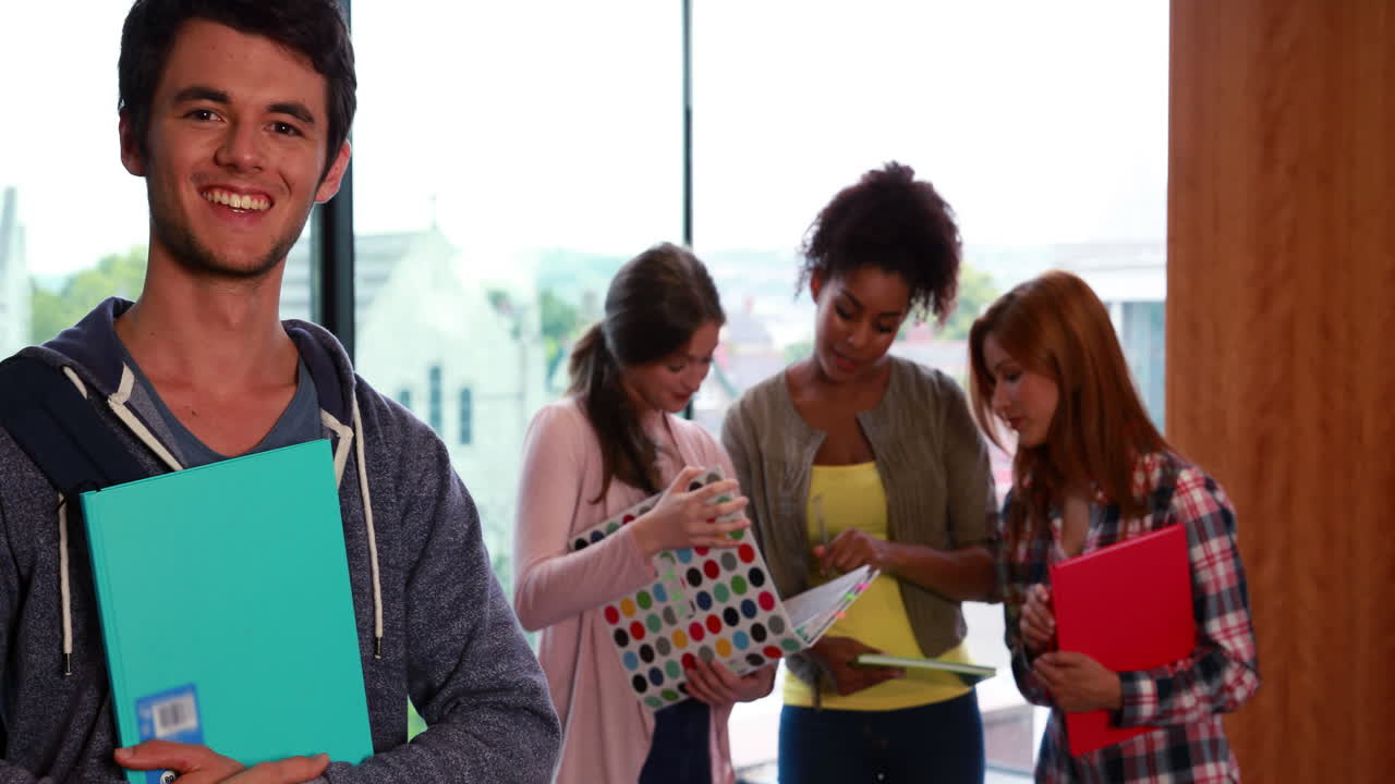 estudiante sonriendo a la cámara en la biblioteca