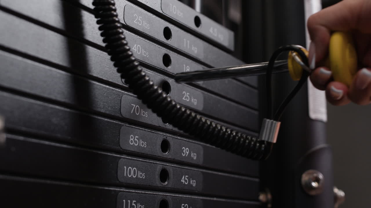 Person Loading Weights onto a Barbell in a Gym