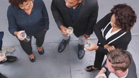 overhead shot of business team socializing with drinks at after work meeting in modern office