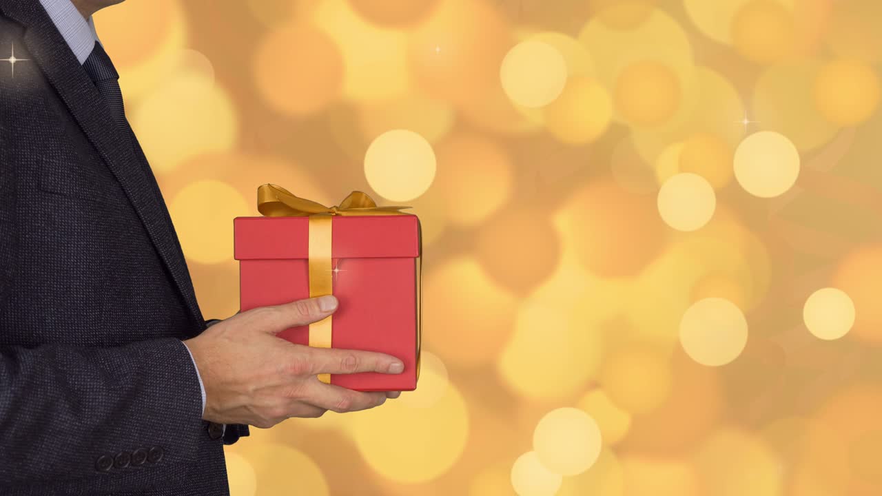 카우카스 사업가 고 빨간 선물 상자를 주세요. 고전적인 비즈니스 슈트를 입은 성인 남자가 은 선물 상자 니다. 추상적인 배경 금 플래시 박거리고 반이는 원 조명 보케.