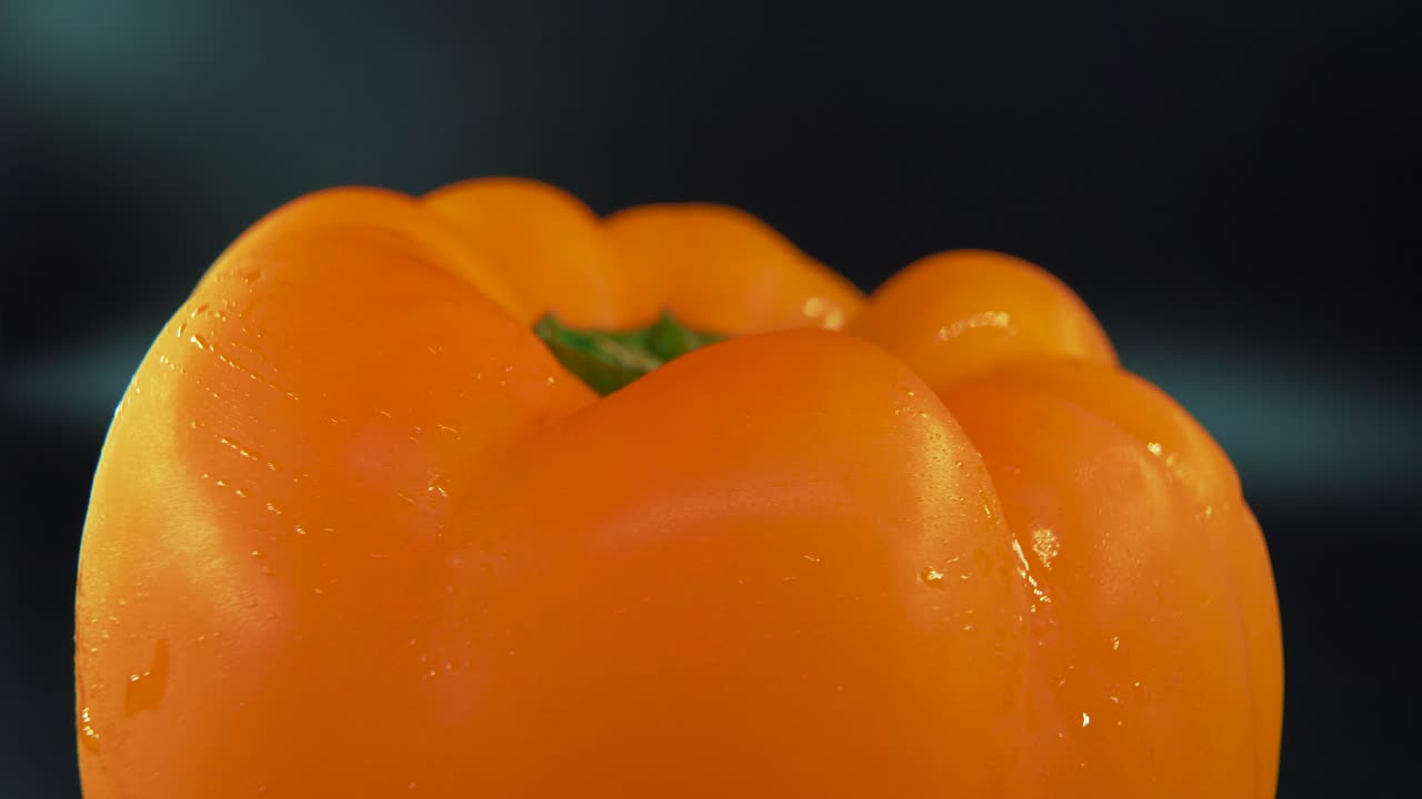 A macro close up shot of a wet sweet yellow pepper on a 360 rotating stand, shiny sweaty water drops, cinematic studio lighting, slow motion, smooth movement, 4k video