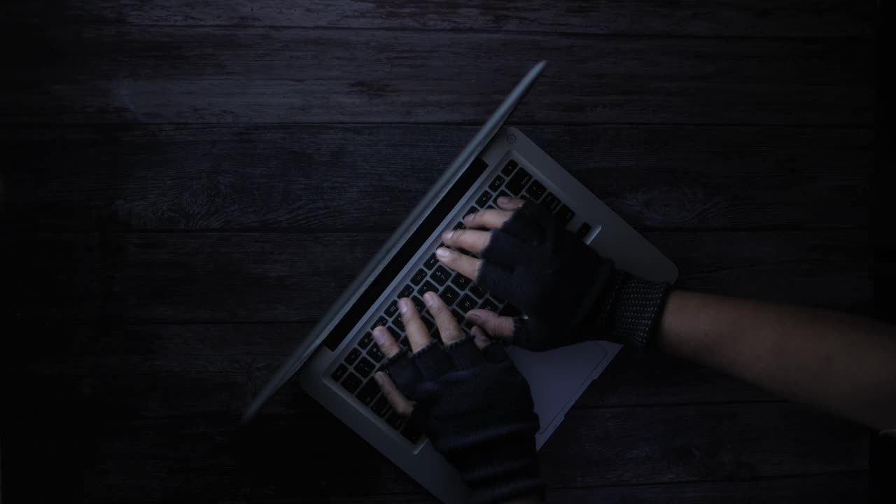 Pessoa usando um laptop com luvas