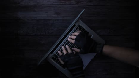 person using a laptop with gloves