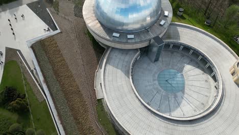 Stars-observatory-with-a-sundial-during-a-beautiful-summer-day,-surrounded-by-lush-greenery,-grass,-and-trees-under-a-clear-blue-sky