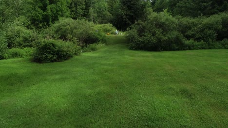 un vuelo bajo de drones sobre un campo recién cortado que se eleva para revelar un estanque de pesca privado en el norte del estado de nueva york cerca de walton