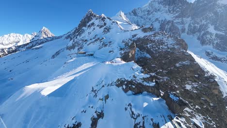 vista aérea de los picos de las montañas nevadas en la temporada de esquí en un día soleado con un cielo azul claro