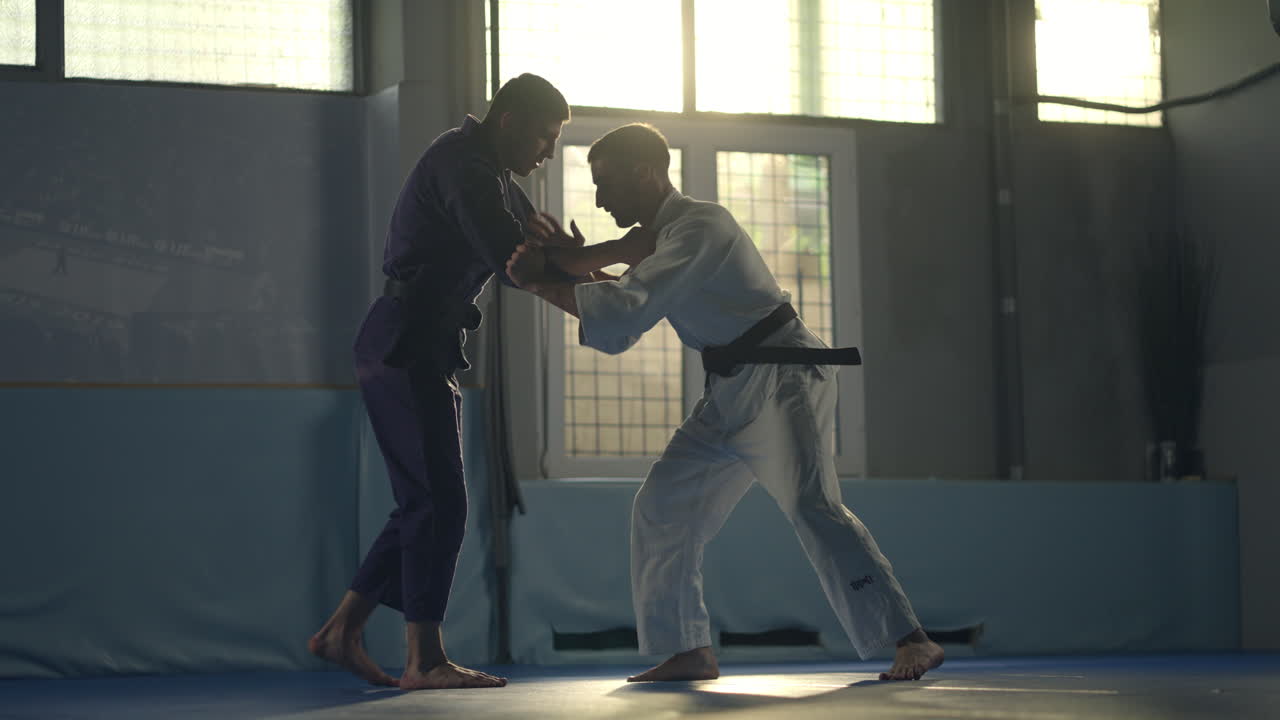 Two people practicing judo in a gym