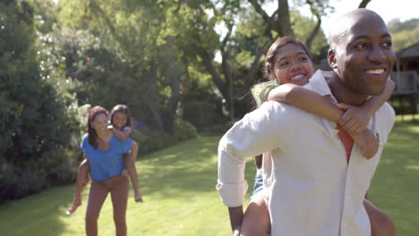 playing in park, parents giving piggyback rides to their children