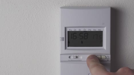 reducción de la temperatura del termostato de calefacción, visualización y vista de cerca a mano, reducción de los costes