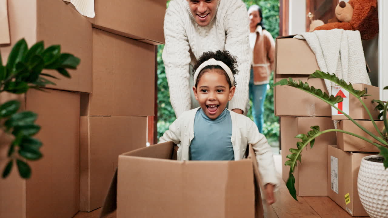padre, jugando y niño en la caja en la casa nueva