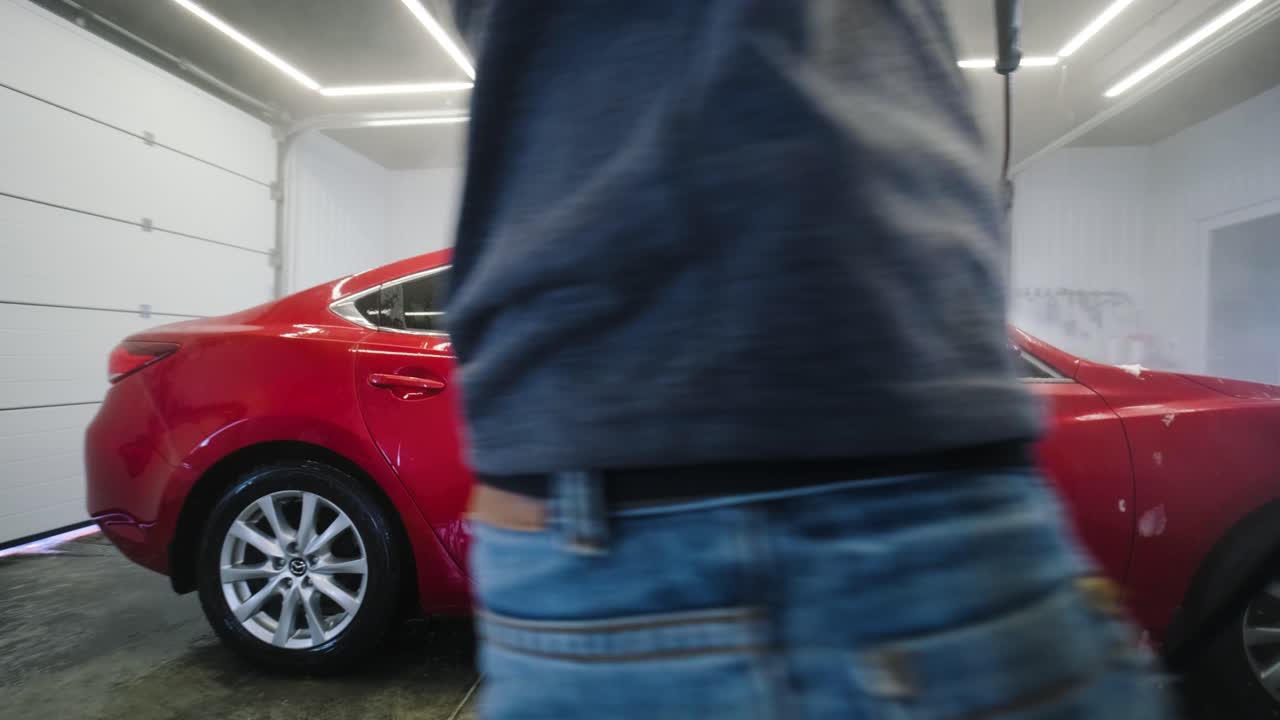 lavado de automóviles limpieza con espuma y agua a alta presión. coche rojo