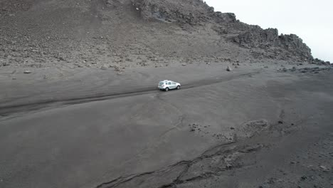 aerial follow shot of a 4x4 driving through rugged remote mountain roads in iceland.