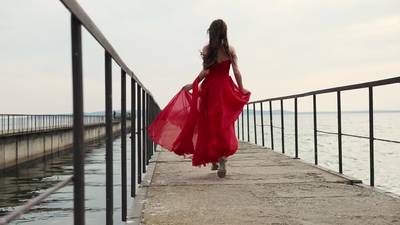 Woman in Red Dress Running on a Pier