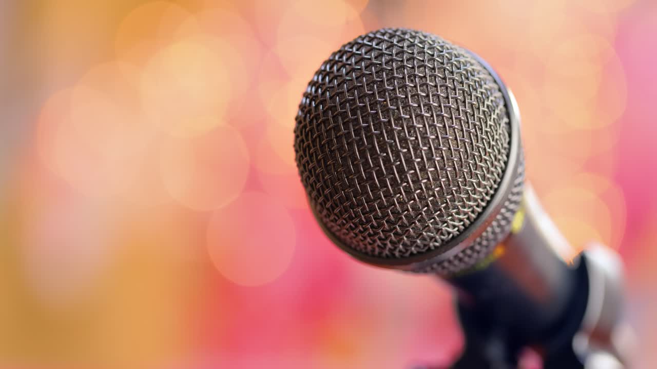 Microphone on stage against a blurry light ,blurry background.