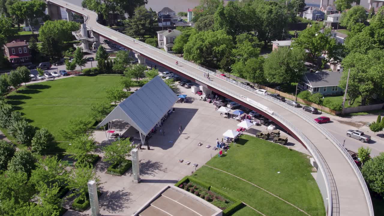Aerial view of a farmers market in a small town, with tents, vendors, and community activity. Great for local culture, agriculture, and small business themes.